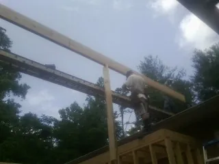 Carpenter setting a ridge beam over a new addition frame — Ice Dam Removal by Roofing Brothers in Valley Lee