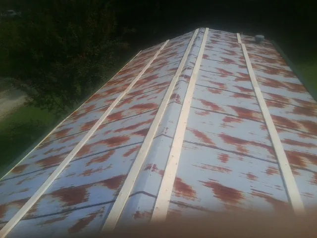 Rusted metal roof panels with new wood purlins before replacement — Storm Damage Roof Repair in Valley Lee by Roofing Brothers